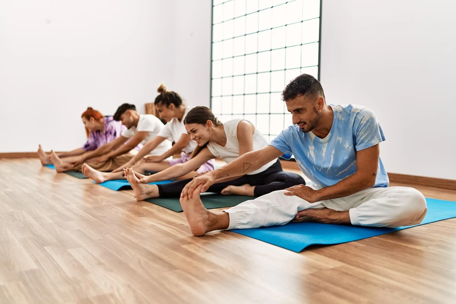 group-young-people-smiling-happy-training-yoga-sport-center_839833-7403